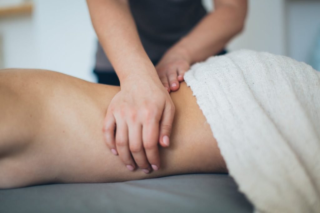 Close-up of a woman receiving a therapeutic massage in a serene spa setting with a white towel.